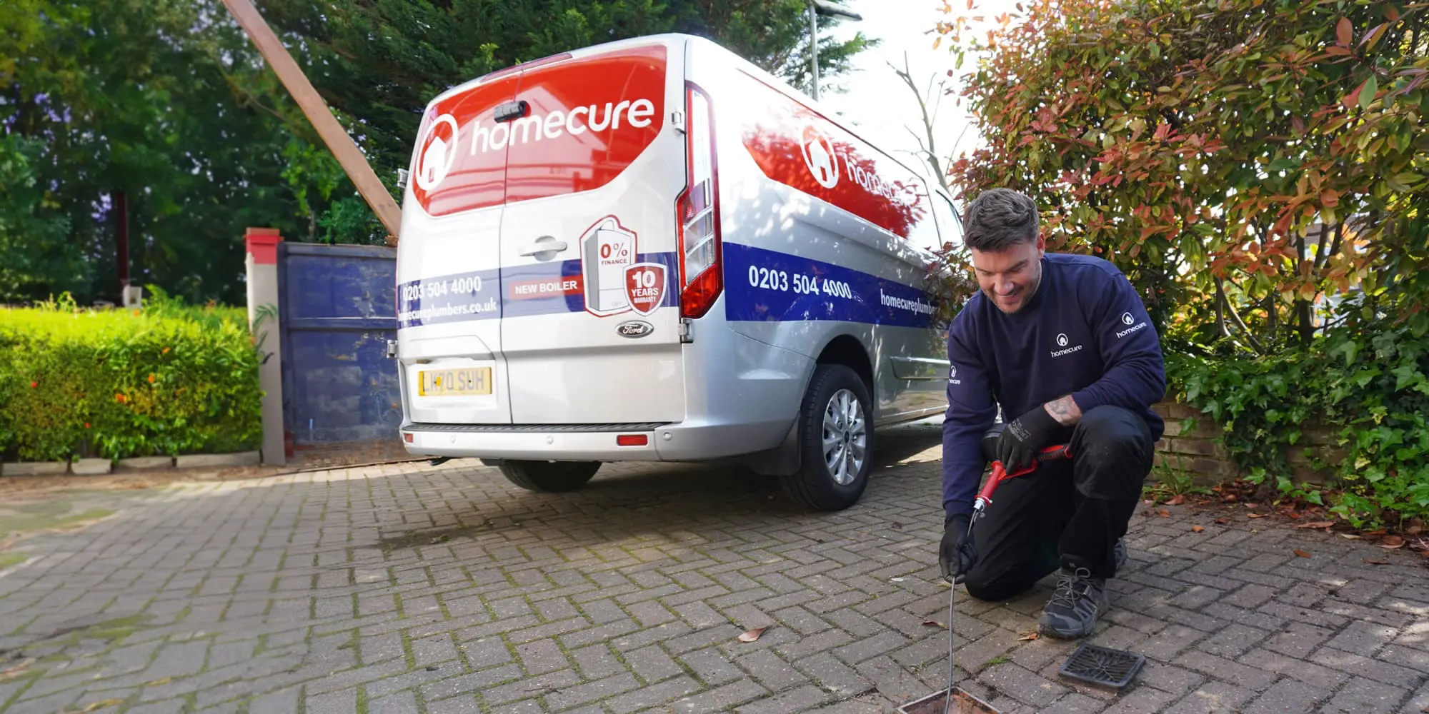 Homecure employee clearing a drain
